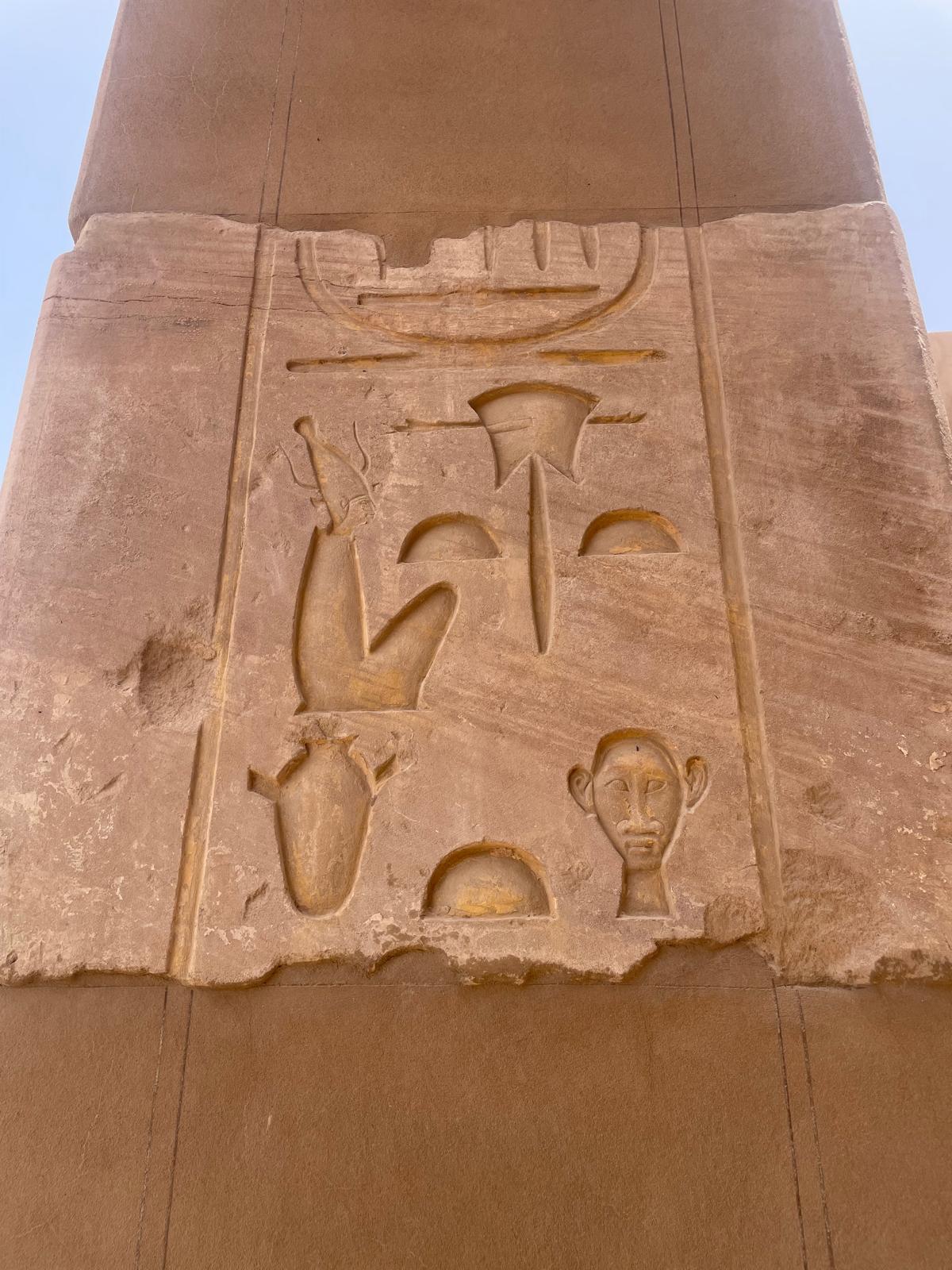 Reading the pillar — the face still looks back.